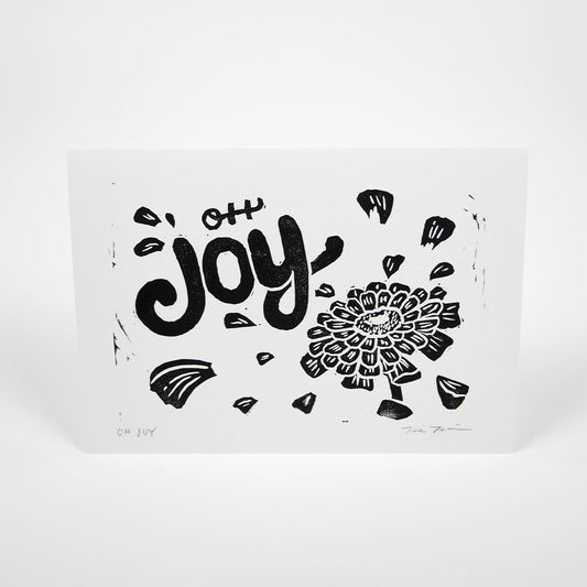 White paper with "Oh Joy" hand lettering with an illustration of a zinnia with petals floating around the text.