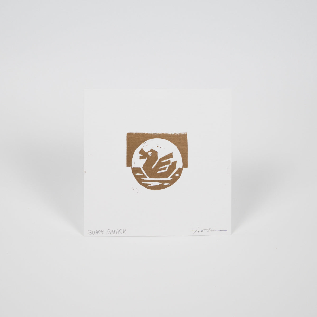 White square paper with a gold duck on water illustration.