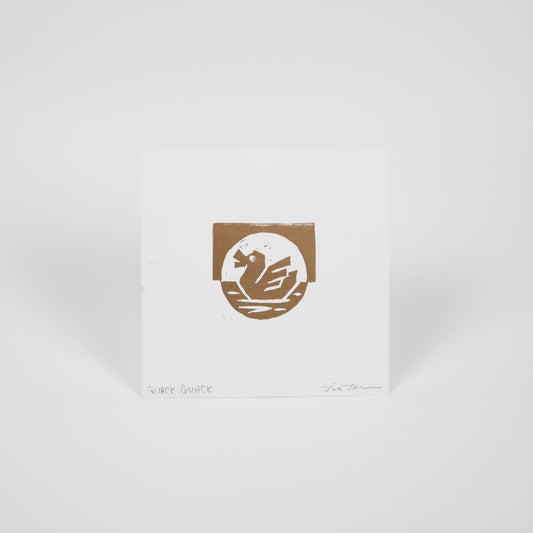 White square paper with a gold duck on water illustration.