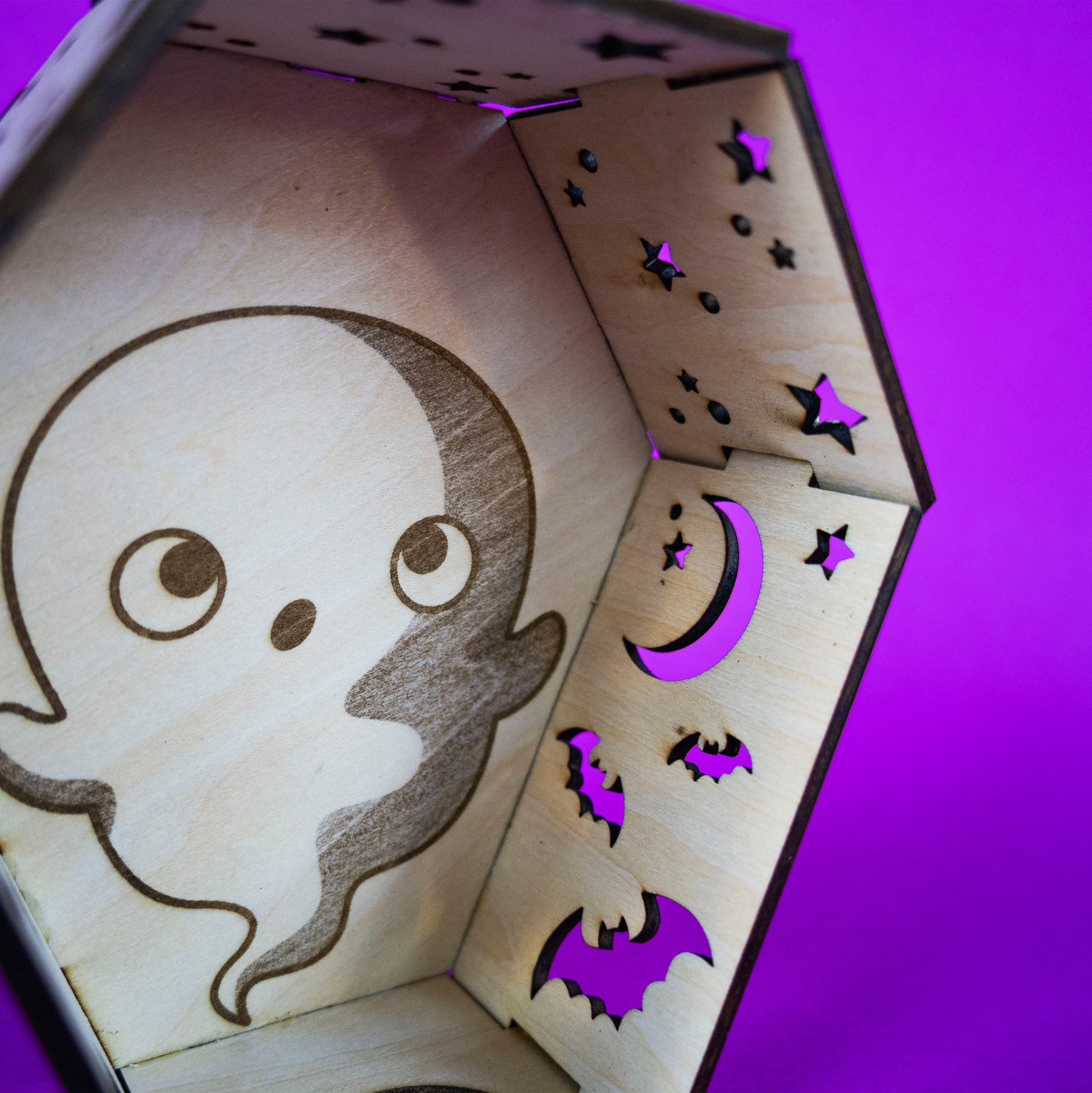 Detail shot of Ghost Coffin Candle Cutie. A coffin made out of interlocking wood pieces with cut outs and space for a tea light candle.