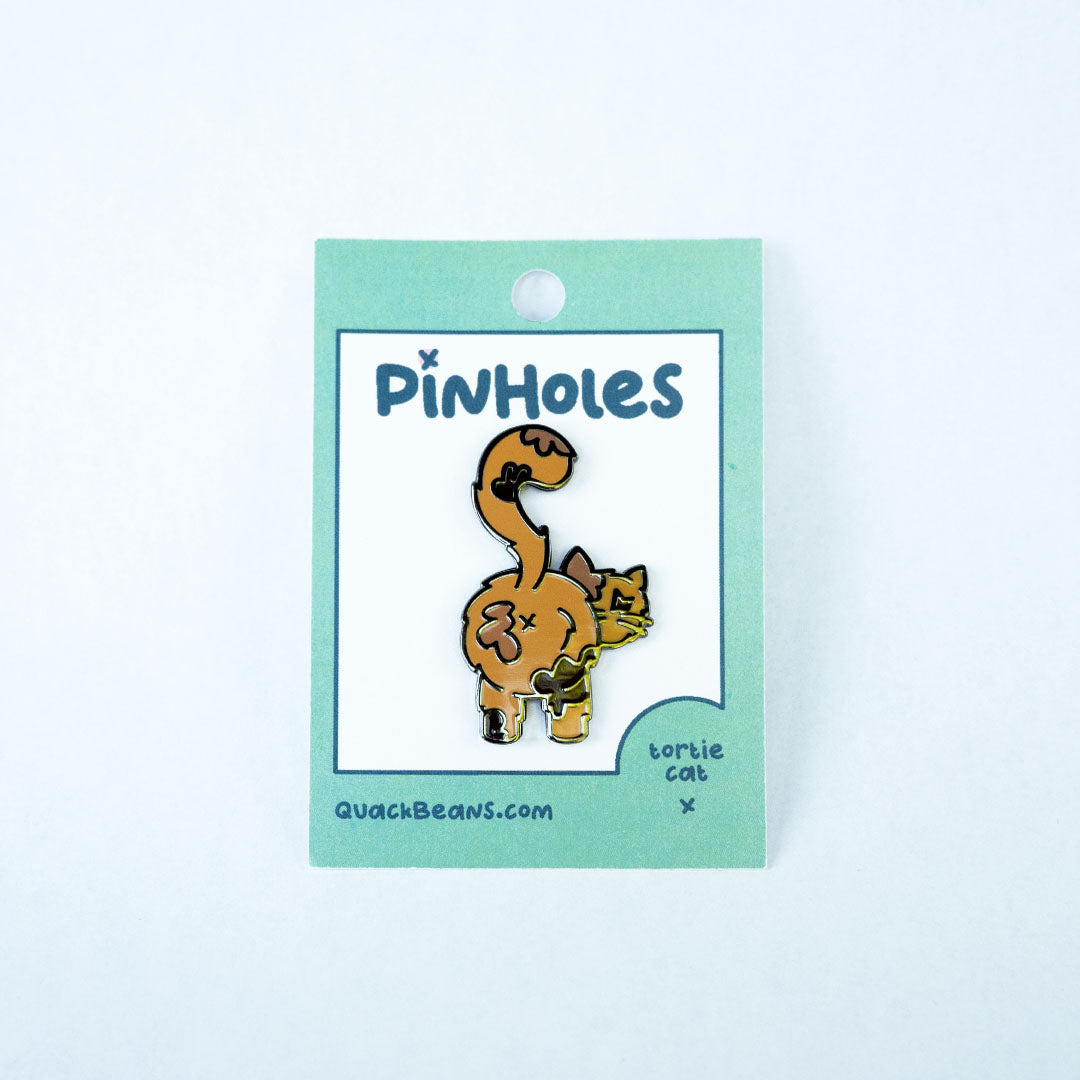 Tortoise shell cat butt pin on green Pinholes hang tag card.