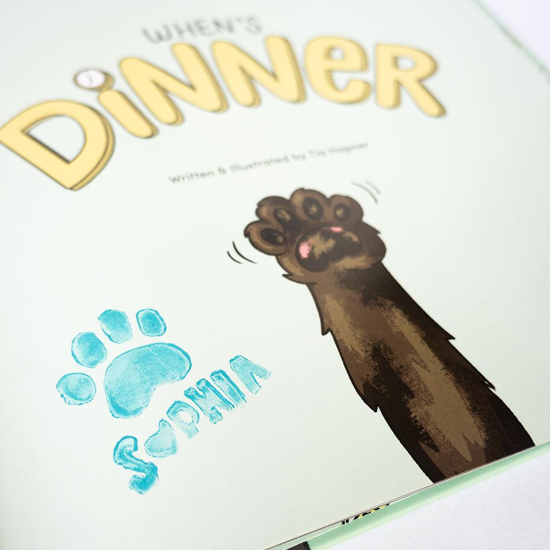 When's Dinner book detail of inside title page with a kitty paw waving as well as a stamped kitty signature