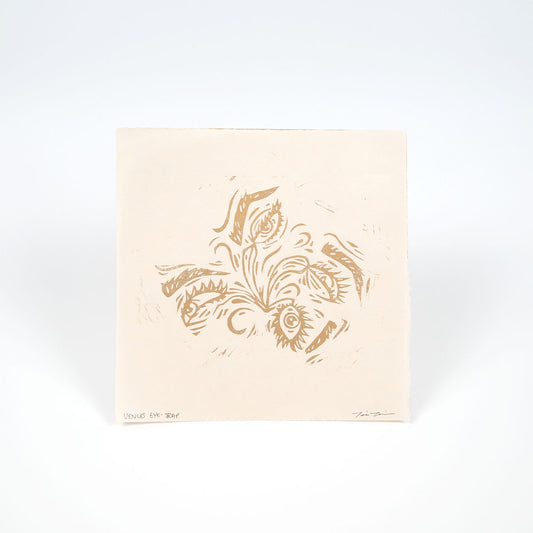 Square cream colored paper with gold illustration of eyeballs that look like venus fly traps. 