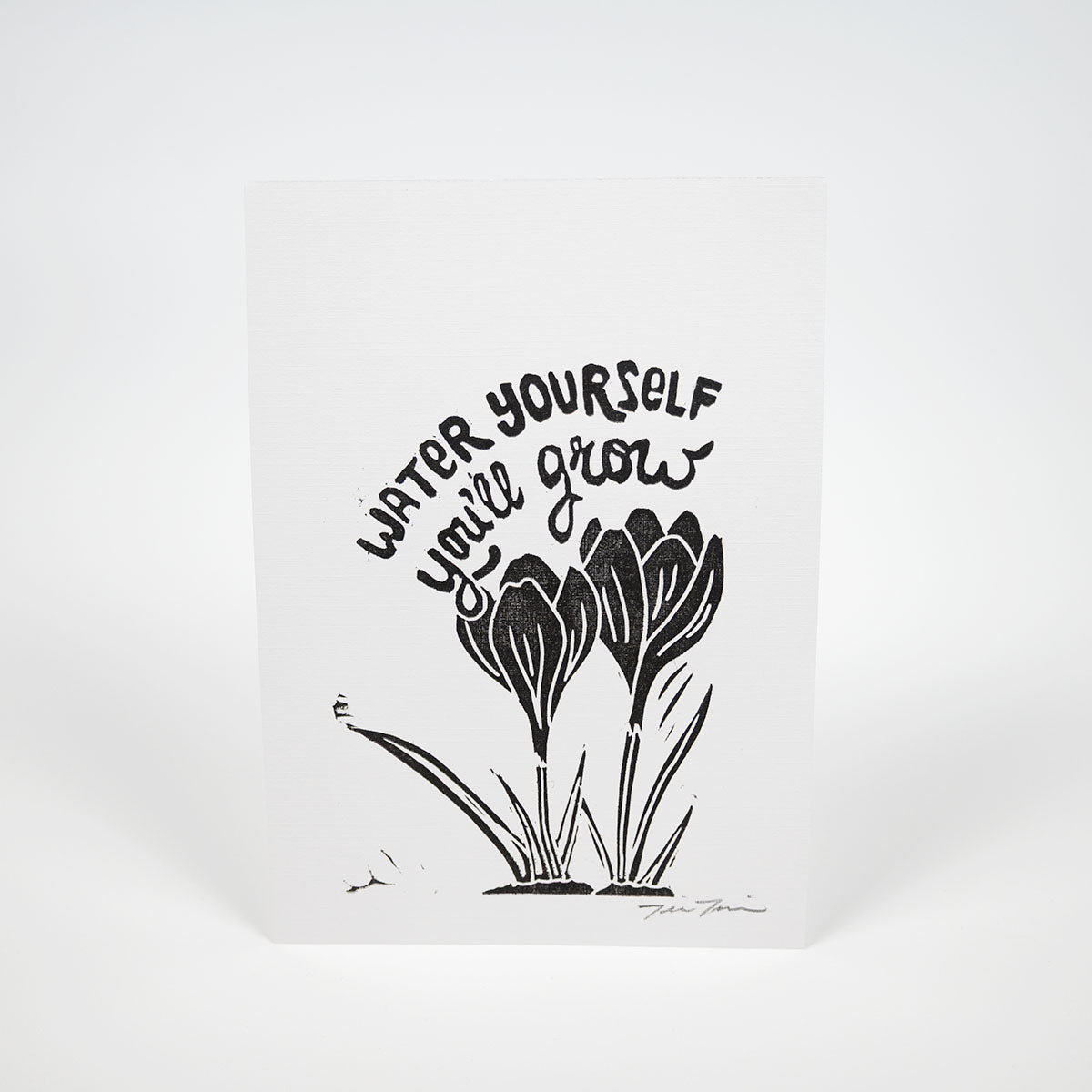 Black illustration of crocuses in the bottom right corner of white paper with "Water Yourself You'll Grow" hand lettered above them. 
