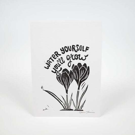 Black illustration of crocuses in the bottom right corner of white paper with "Water Yourself You'll Grow" hand lettered above them. 