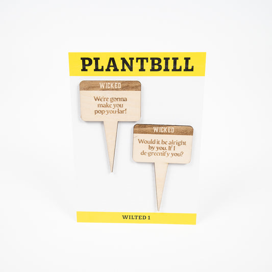 White and yellow card with "Plantbill" across the top and "Wilted 1" across the bottom. In the middle are two wooden plant/garden stakes with "We're gonna make you pop-you-lar" and "Would it be alright by you. If I de-greenify you?" engraved on them. 