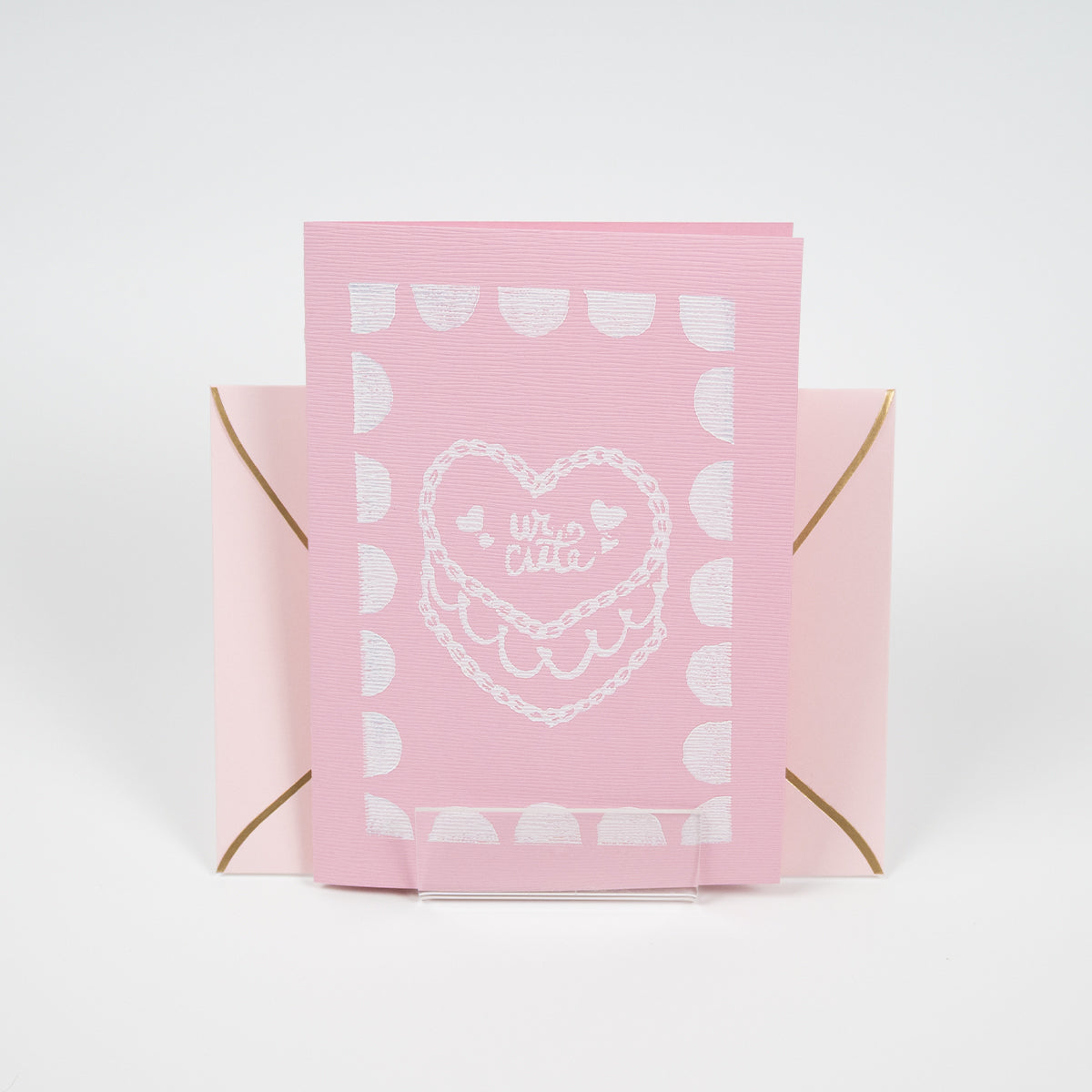 Light pink greeting card with a"ur cute" cake illustration in front of a light pink envelope. 